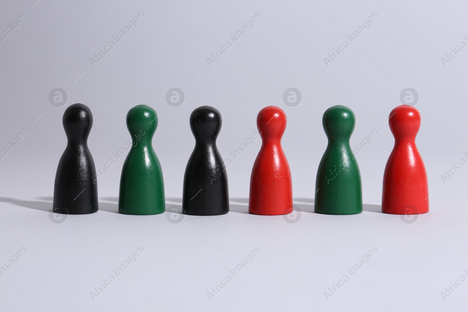 Photo of Equality concept. Different game pieces on light background