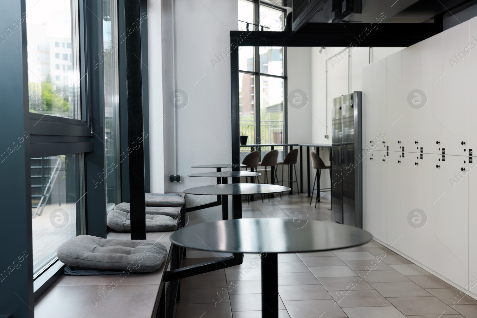 Photo of Hostel dining room interior with modern furniture and white lockers