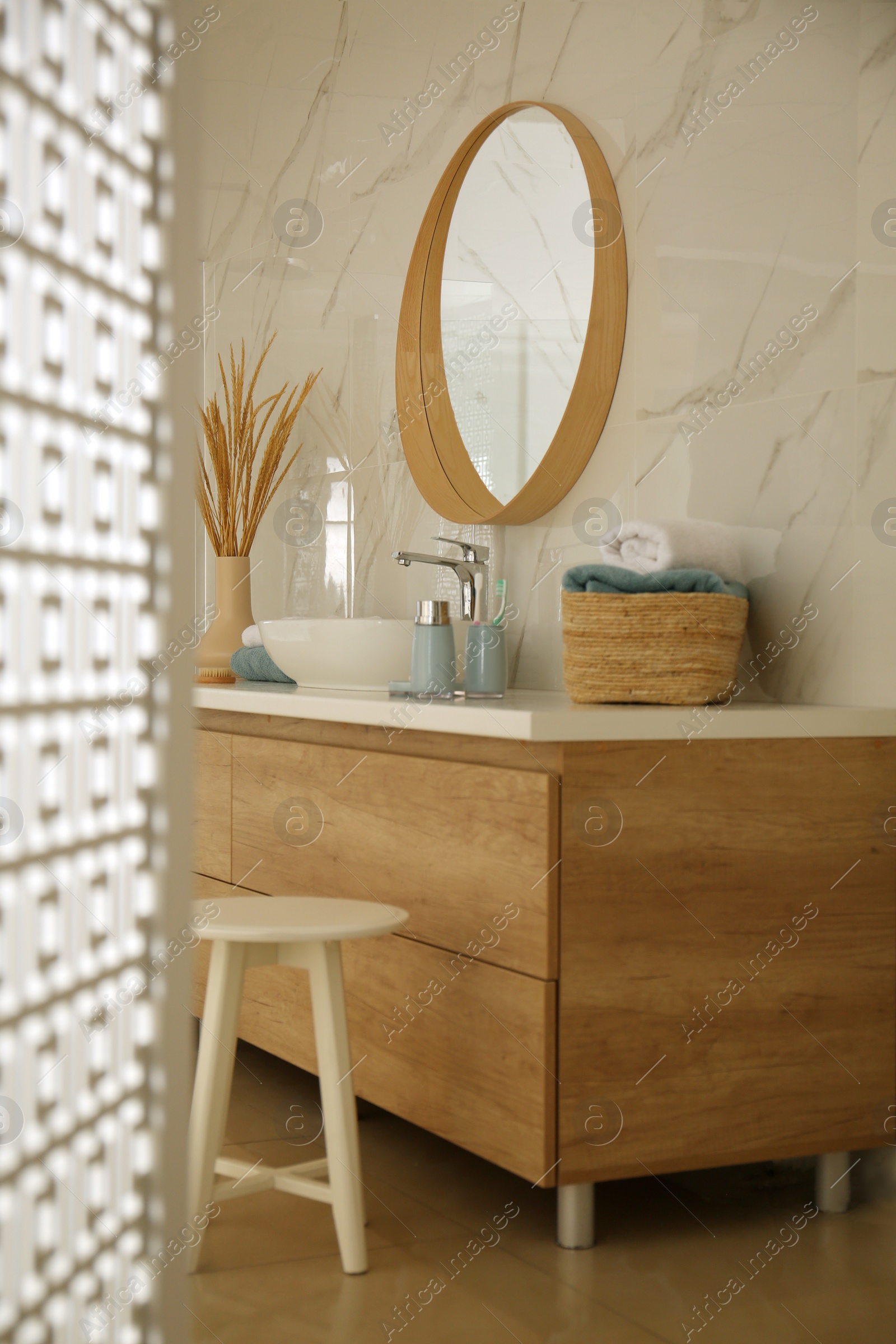 Photo of Round mirror over vessel sink in stylish bathroom interior