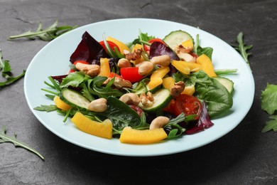 Photo of Tasty fresh vegetarian salad on black table