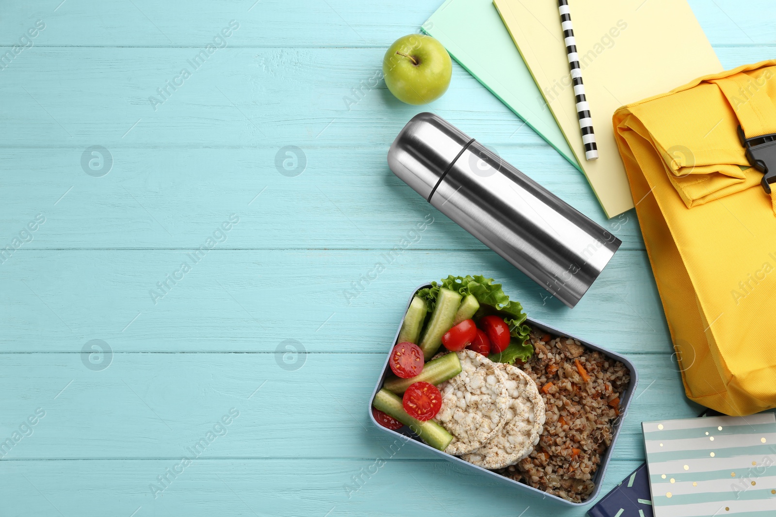 Photo of Flat lay composition with thermos and lunch box on turquoise wooden background, space for text