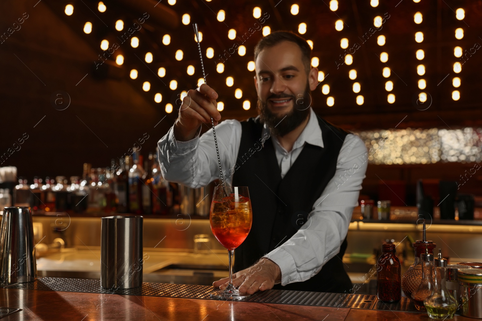 Photo of Bartender making fresh alcoholic cocktail at bar counter