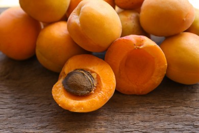 Delicious ripe whole and cut apricots on wooden table, closeup