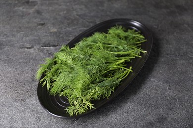 Photo of Sprigs of fresh green dill on grey table