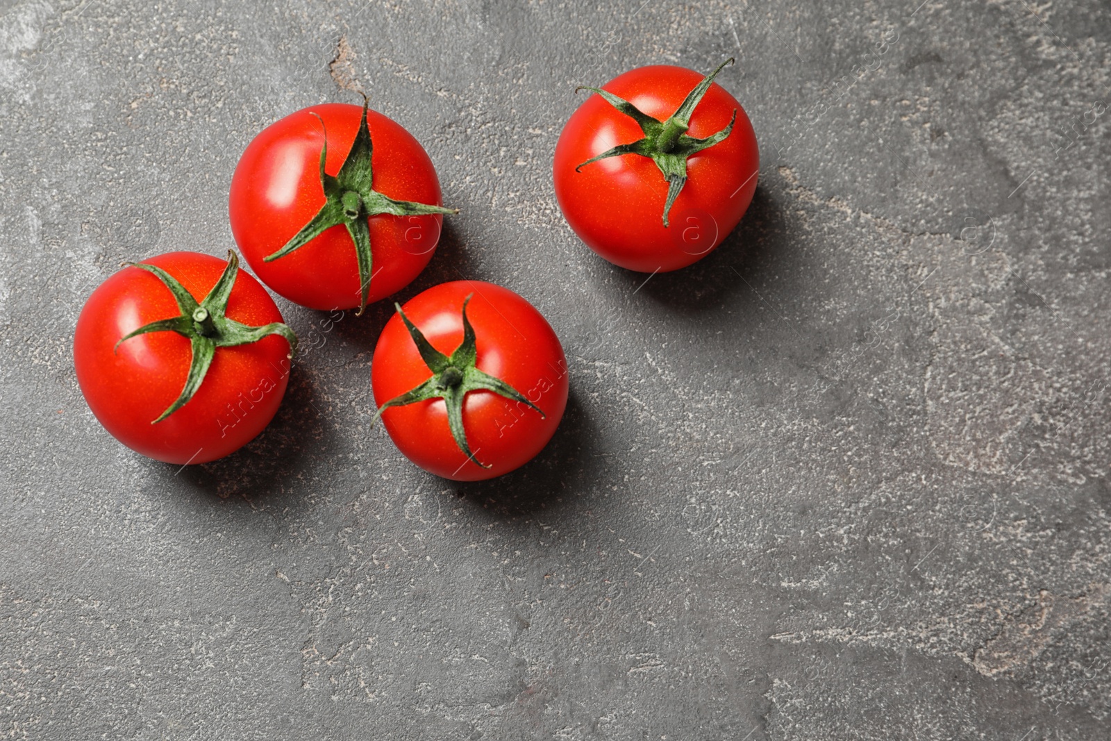 Photo of Fresh cherry tomatoes on stone background, top view