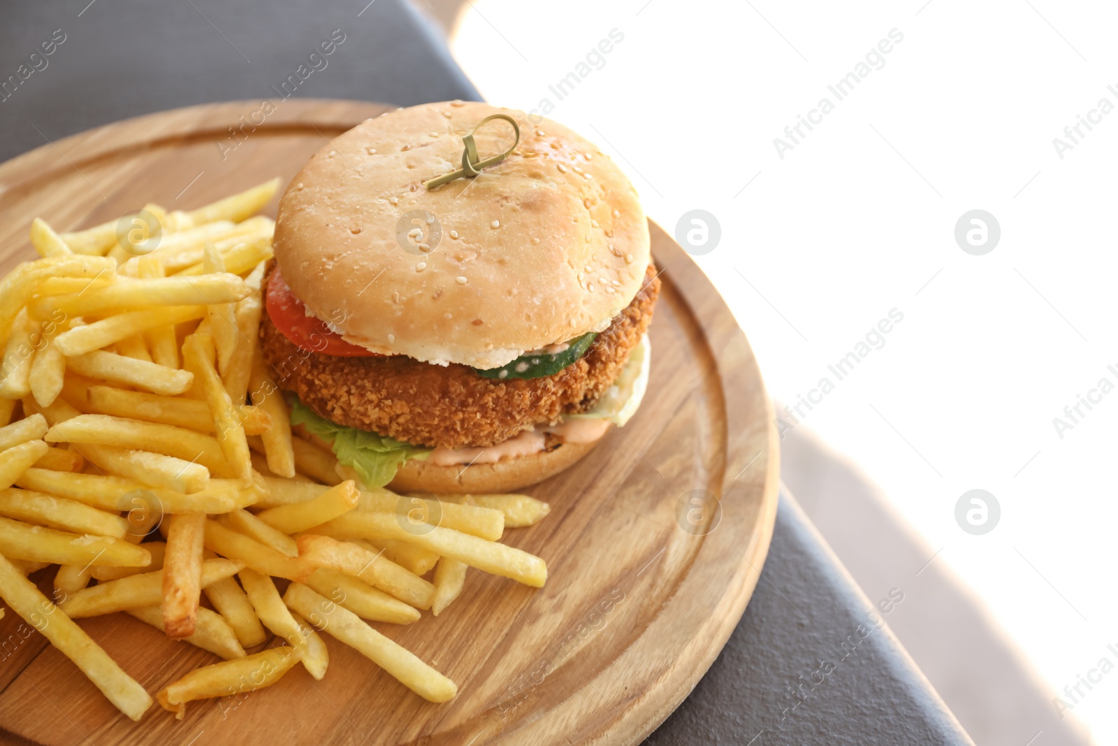 Photo of Delicious beef burger and fried potato on wooden board