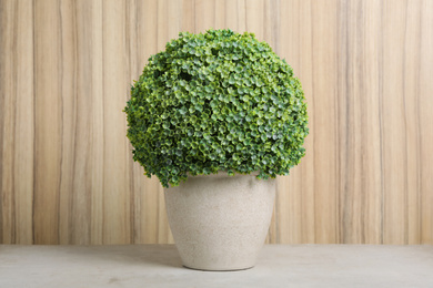 Photo of Artificial plant in flower pot on light grey stone table