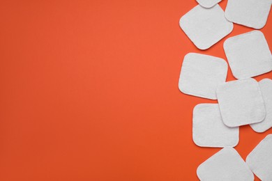 Photo of Many clean cotton pads on orange background, flat lay. Space for text