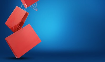 Image of Hot sale. Red shopping bags in air on blue gradient background, space for text