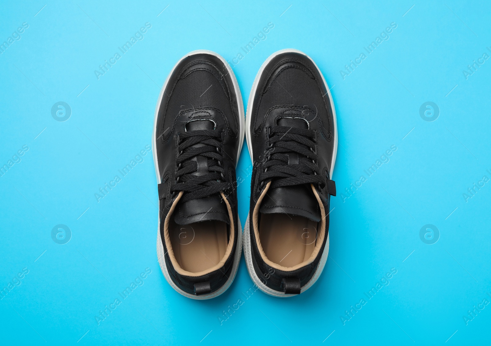 Photo of Pair of stylish shoes on blue background, top view