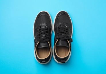 Photo of Pair of stylish shoes on blue background, top view