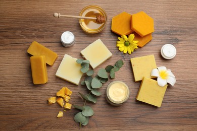 Photo of Flat lay composition with beeswax and cosmetic products on wooden table