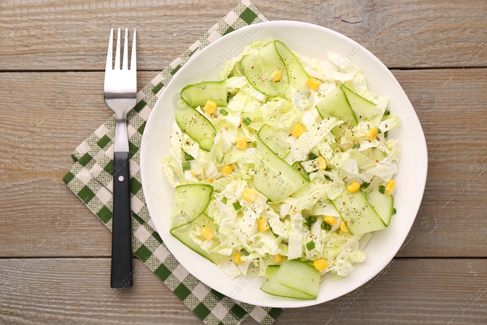 Photo of Tasty salad with Chinese cabbage in bowl served on wooden table, top view