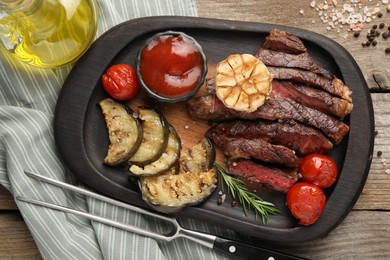 Photo of Delicious grilled beef with vegetables, tomato sauce and spices on wooden table, top view