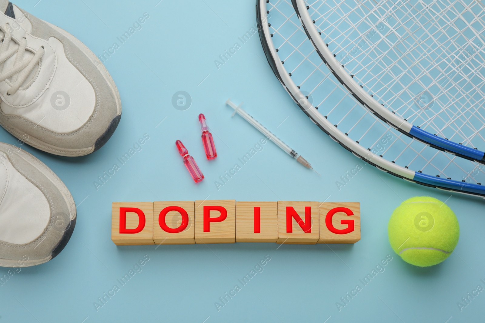 Photo of Wooden cubes with word Doping, drugs and sports equipment on turquoise background