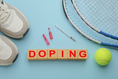 Photo of Wooden cubes with word Doping, drugs and sports equipment on turquoise background
