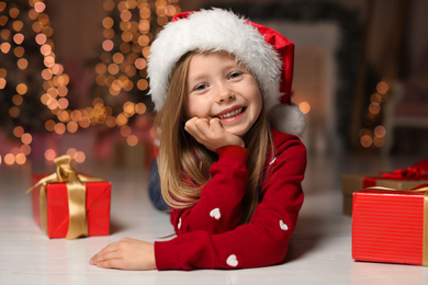 Photo of Cute little child with Christmas gifts at home