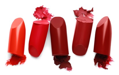 Different bright lipsticks on white background, top view