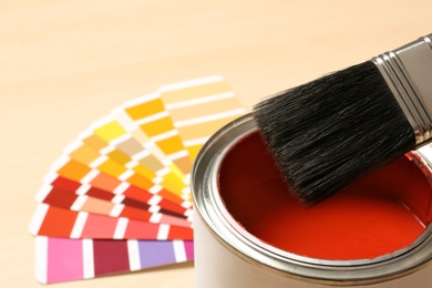 Photo of Red paint can, brush and color palette on table, closeup. Space for text