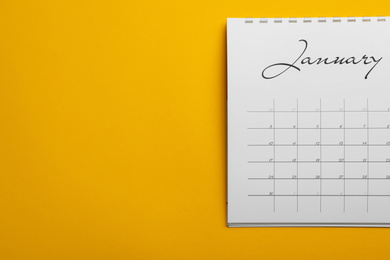 Photo of January calendar on yellow background, top view. Space for text