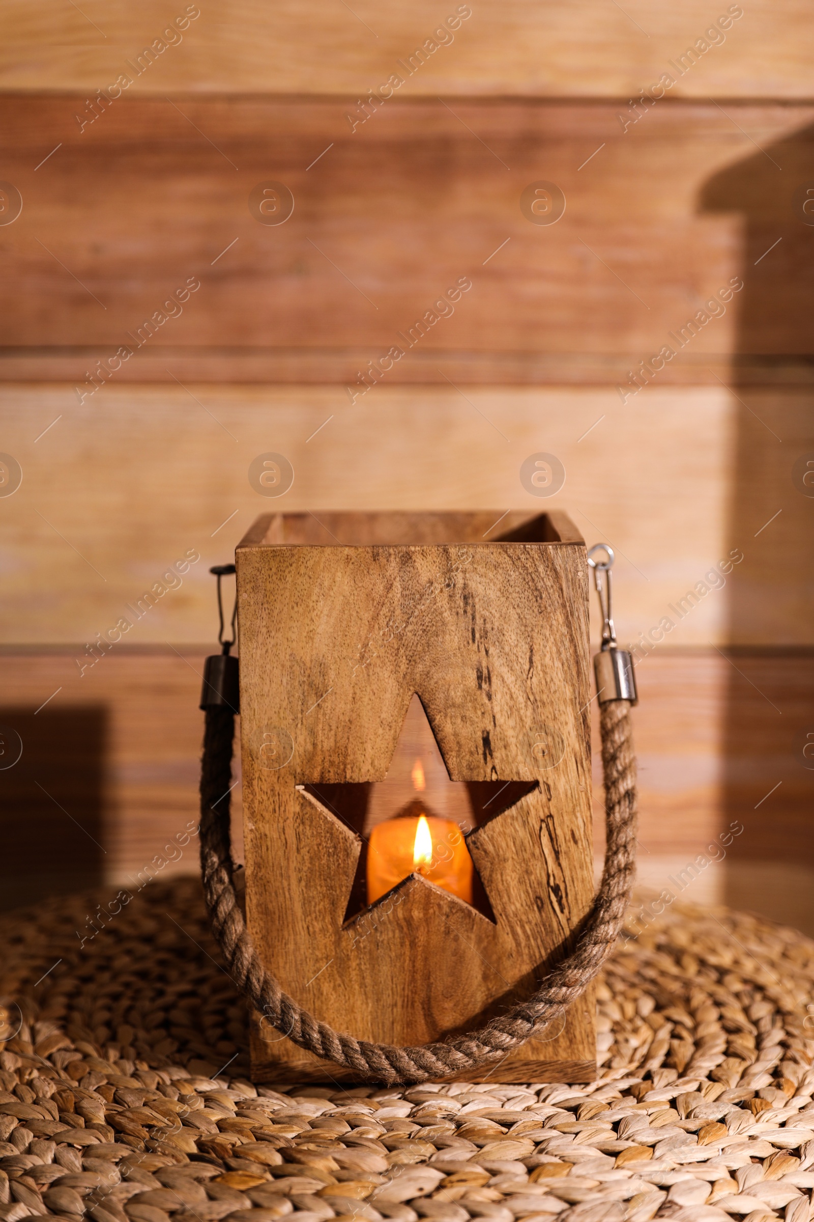 Photo of Burning candle in wooden holder on table