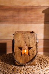 Photo of Burning candle in wooden holder on table