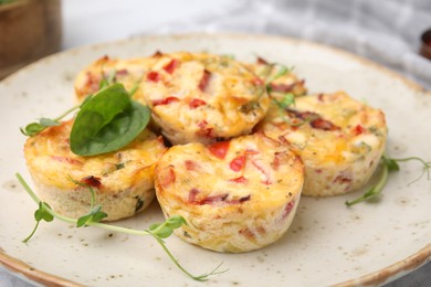 Photo of Freshly baked bacon and egg muffins with cheese on plate, closeup