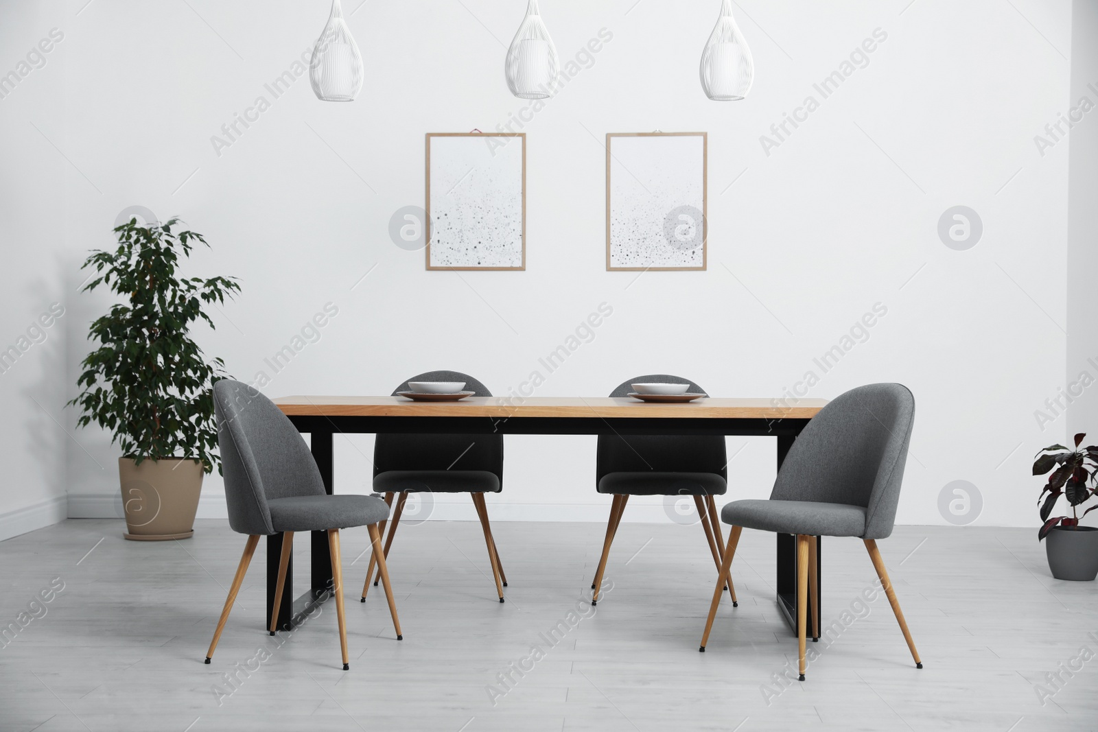 Photo of Stylish wooden table and chairs in light room. Modern interior design