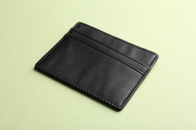 Empty leather card holder on light green background