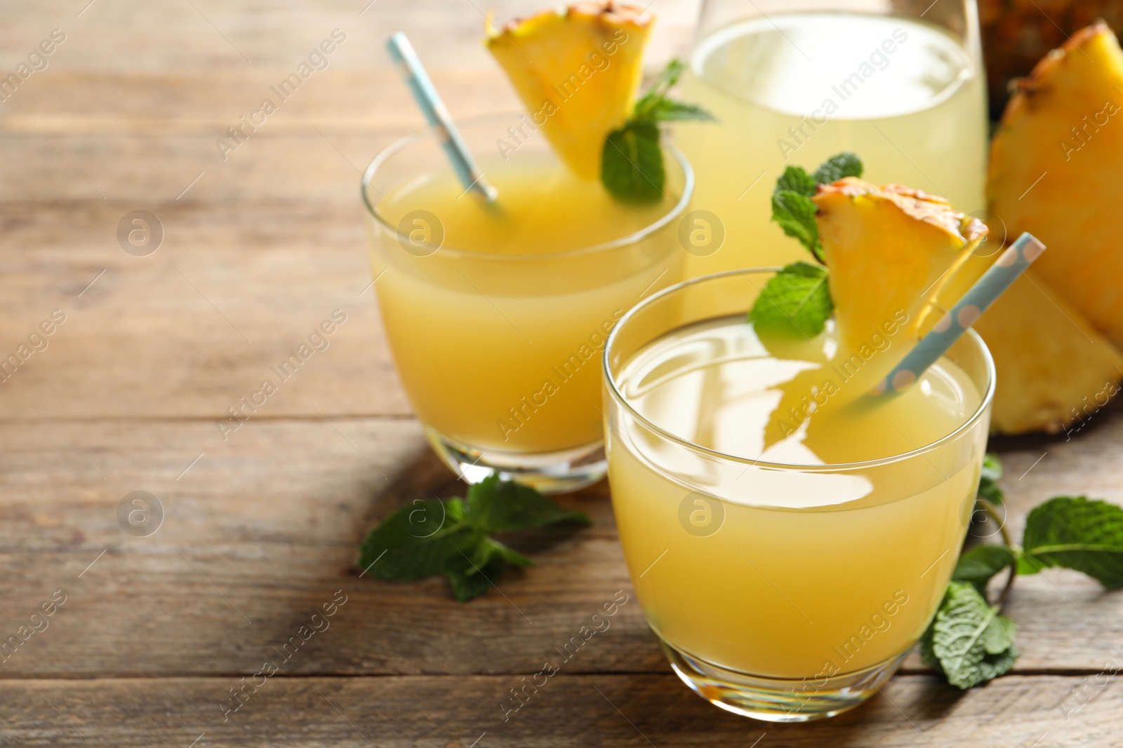 Photo of Delicious fresh pineapple juice with mint on wooden table, closeup. Space for text