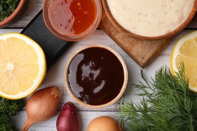 Photo of Different fresh marinades and ingredients on white wooden table, flat lay