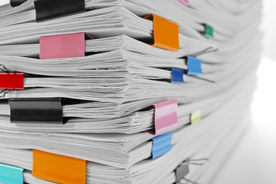 Photo of Stack of documents with colorful binder clips, closeup