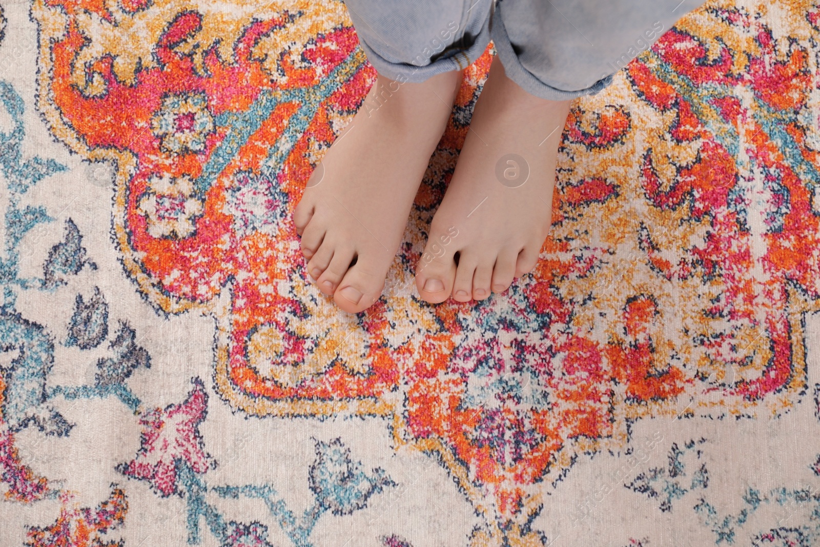 Photo of Woman standing on carpet with pattern, top view. Space for text