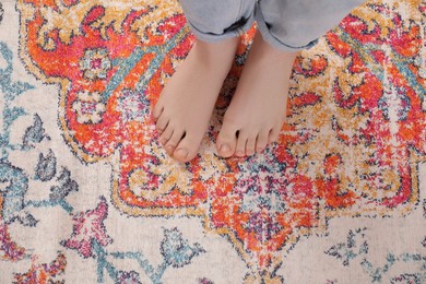 Photo of Woman standing on carpet with pattern, top view. Space for text