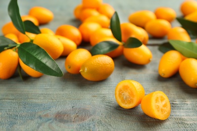 Photo of Fresh ripe kumquats on light blue wooden table