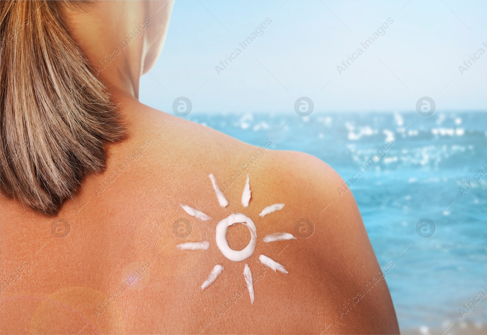 Image of Sun protection. Woman with sunblock on her back near sea, closeup