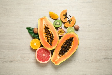 Photo of Fresh ripe papaya and other fruits on wooden table, flat lay