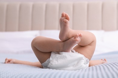 Photo of Little baby in diaper on bed, closeup