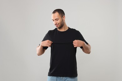 Man wearing black t-shirt on gray background