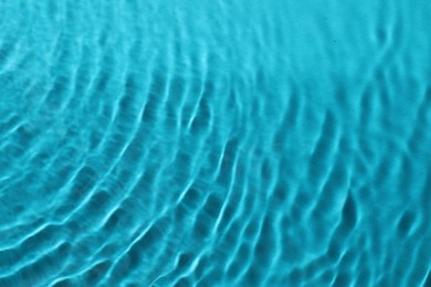 Photo of Rippled surface of clear water on light blue background, top view