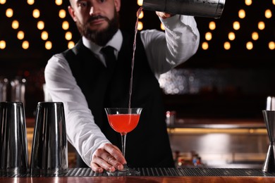 Photo of Bartender preparing fresh Martini cocktail in bar, selective focus