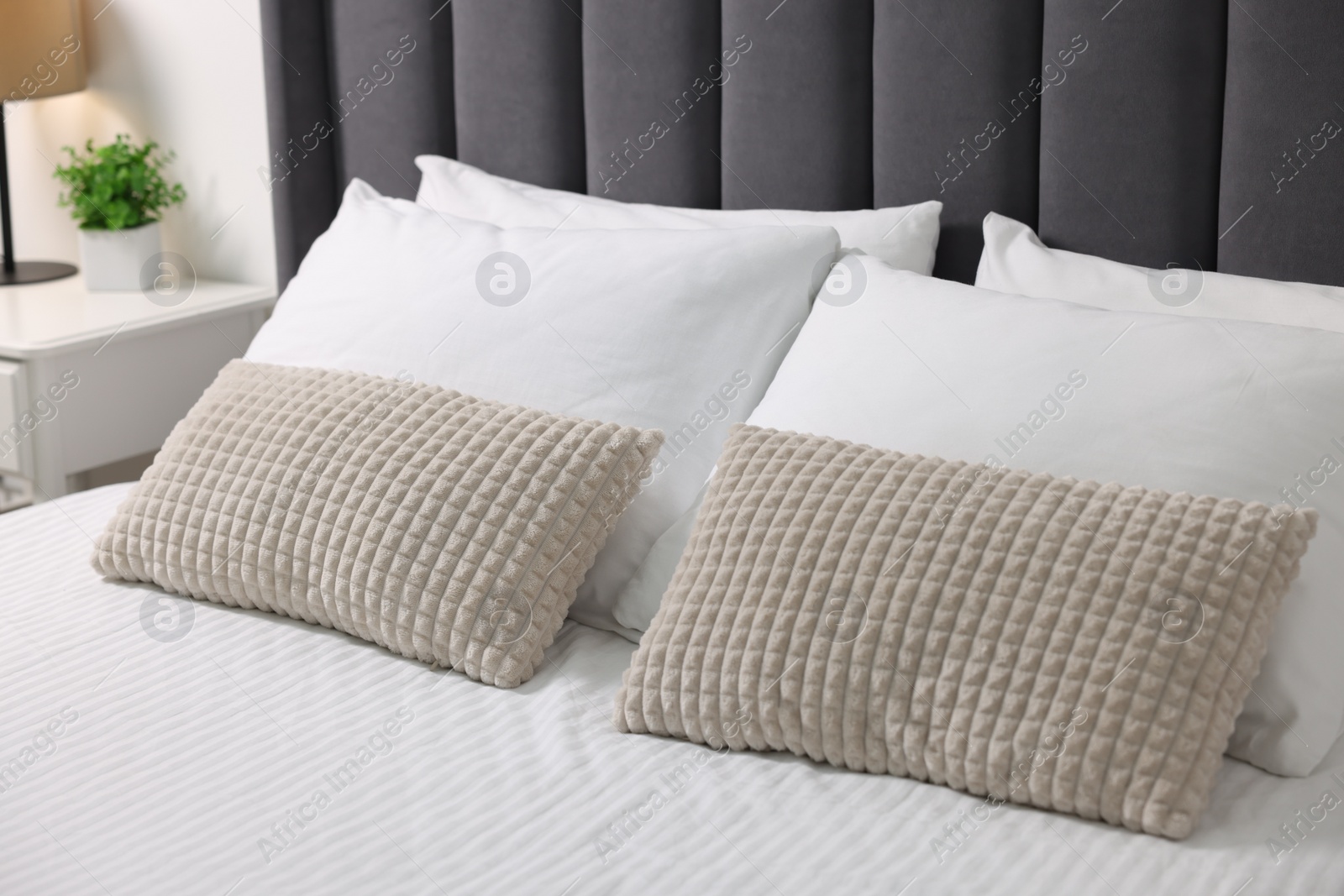 Photo of Soft pillows and bedsheet on bed at home