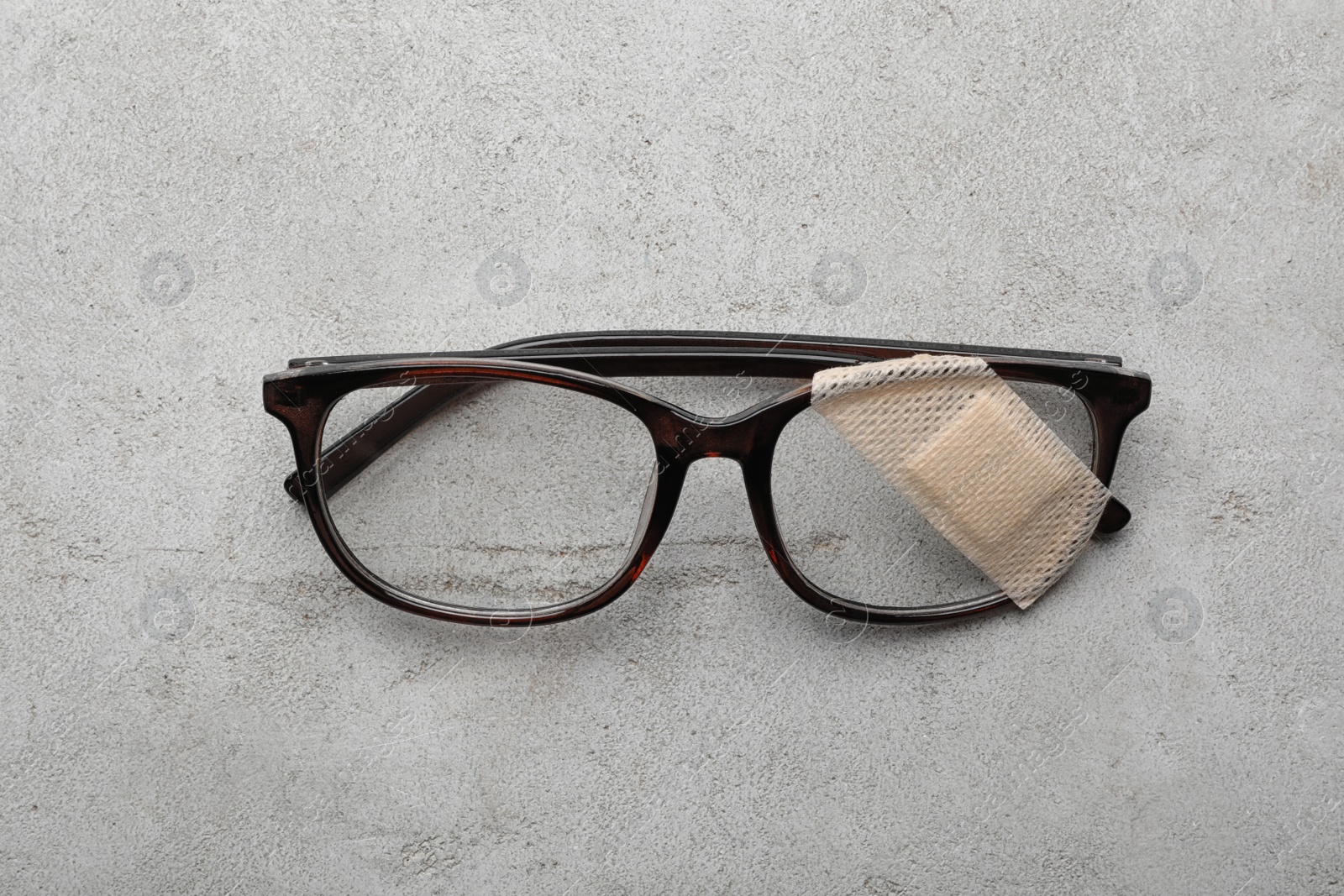 Photo of Glasses with sticking plaster on light grey stone table, top view