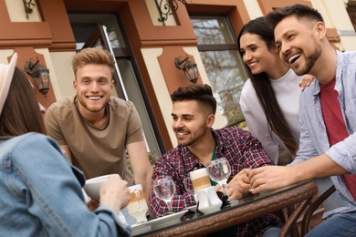 Happy people spending time together at outdoor cafe