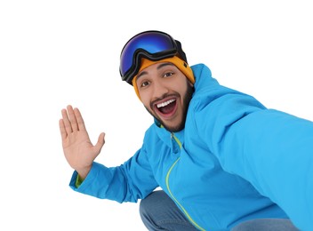 Photo of Smiling young man with ski goggles taking selfie on white background