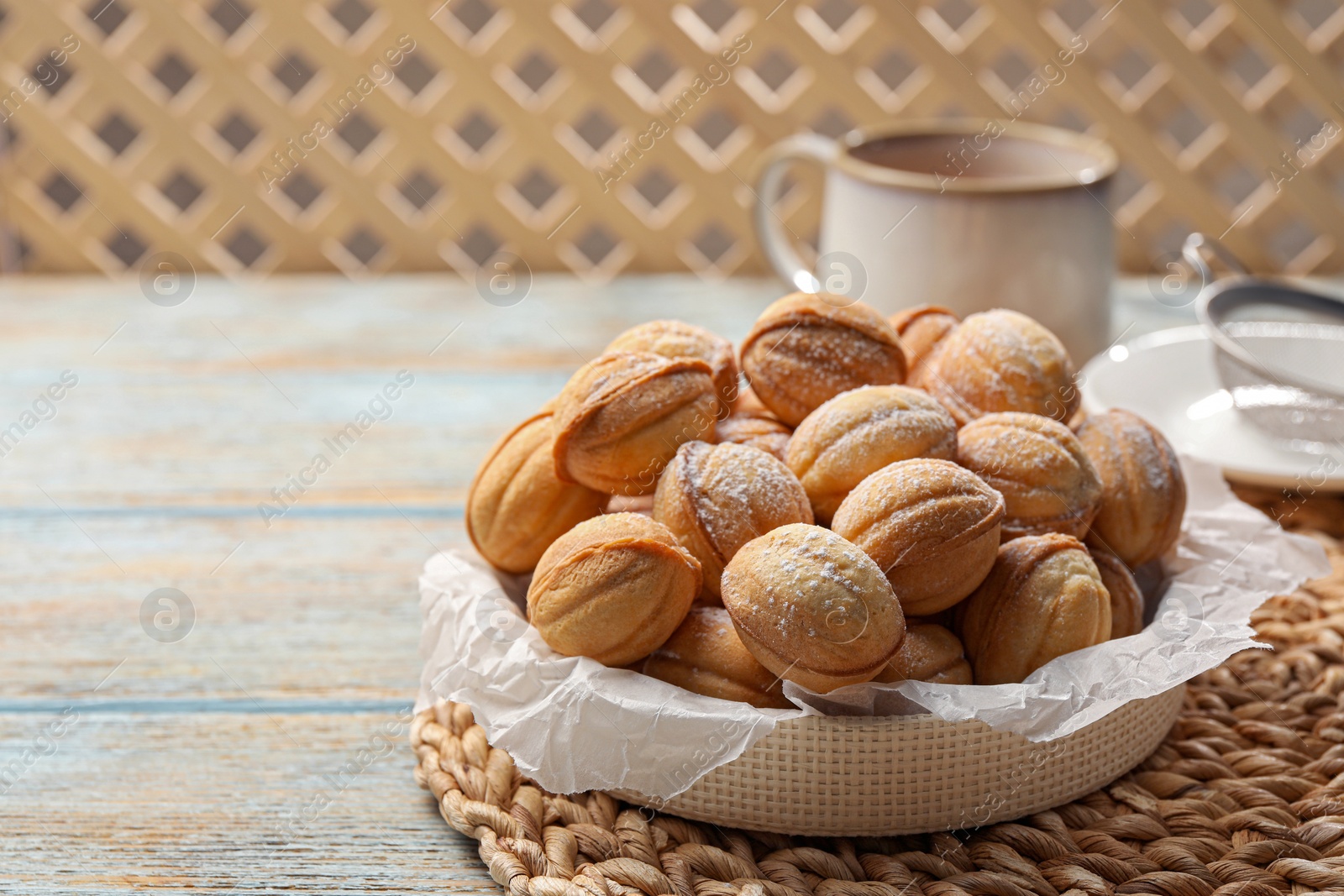 Photo of Bowl of delicious nut shaped cookies on grey wooden table, closeup. Space for text