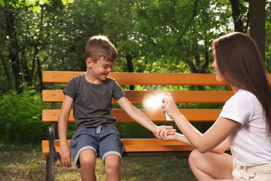 Woman applying insect repellent on her son's arm in park. Tick bites prevention