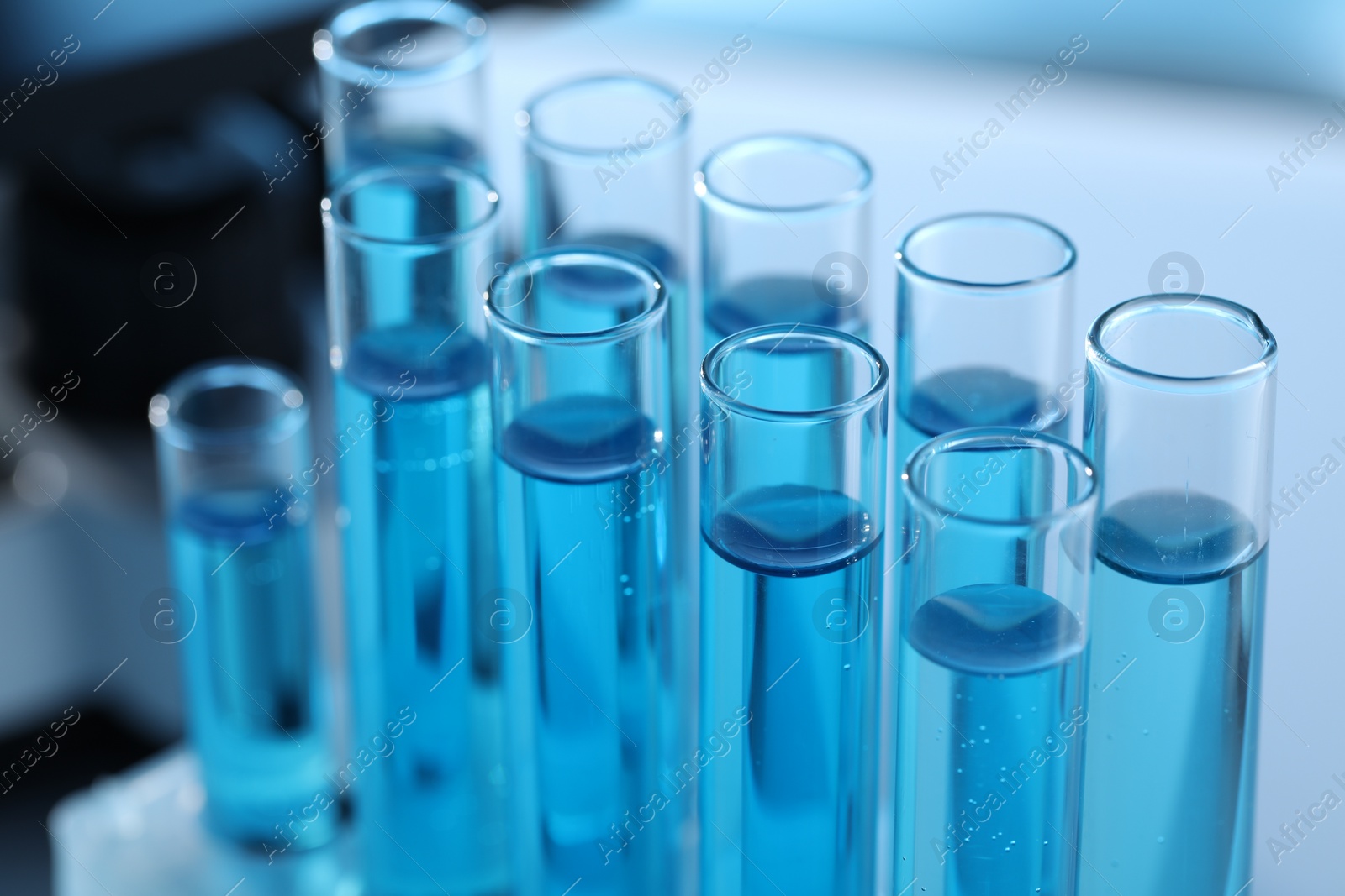 Photo of Test tubes with light blue liquid in laboratory, closeup