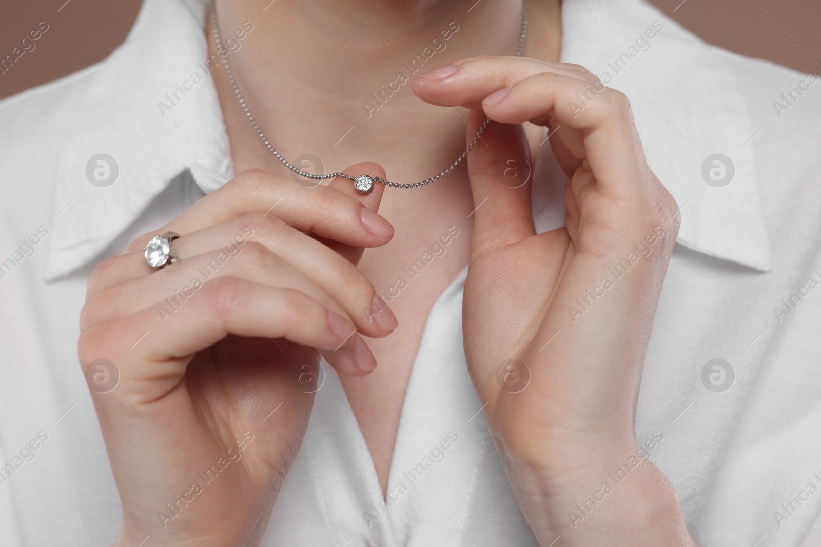 Photo of Woman with elegant jewelry on light brown background, closeup