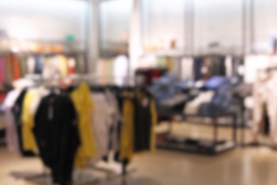 Photo of Blurred view of modern store with different clothes